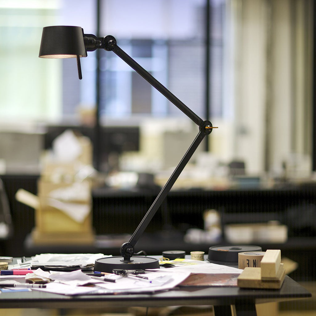 Sfeerbeeld van de Tonone Bolt Desk 2 arm foot bureaulamp in de kleur smokey black.